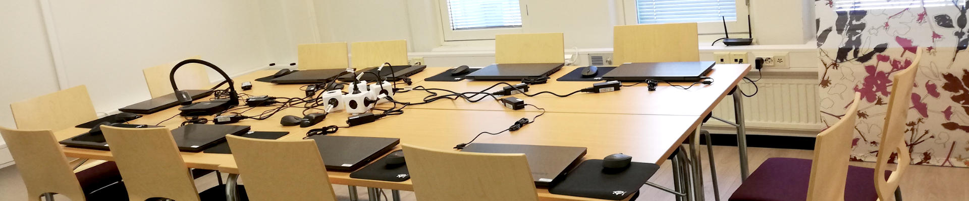 Harjulan Setlementin ryhmätila Tuomi Lahdessa, jossa on kokouksen jäljiltä tiekoneita pöydillä.